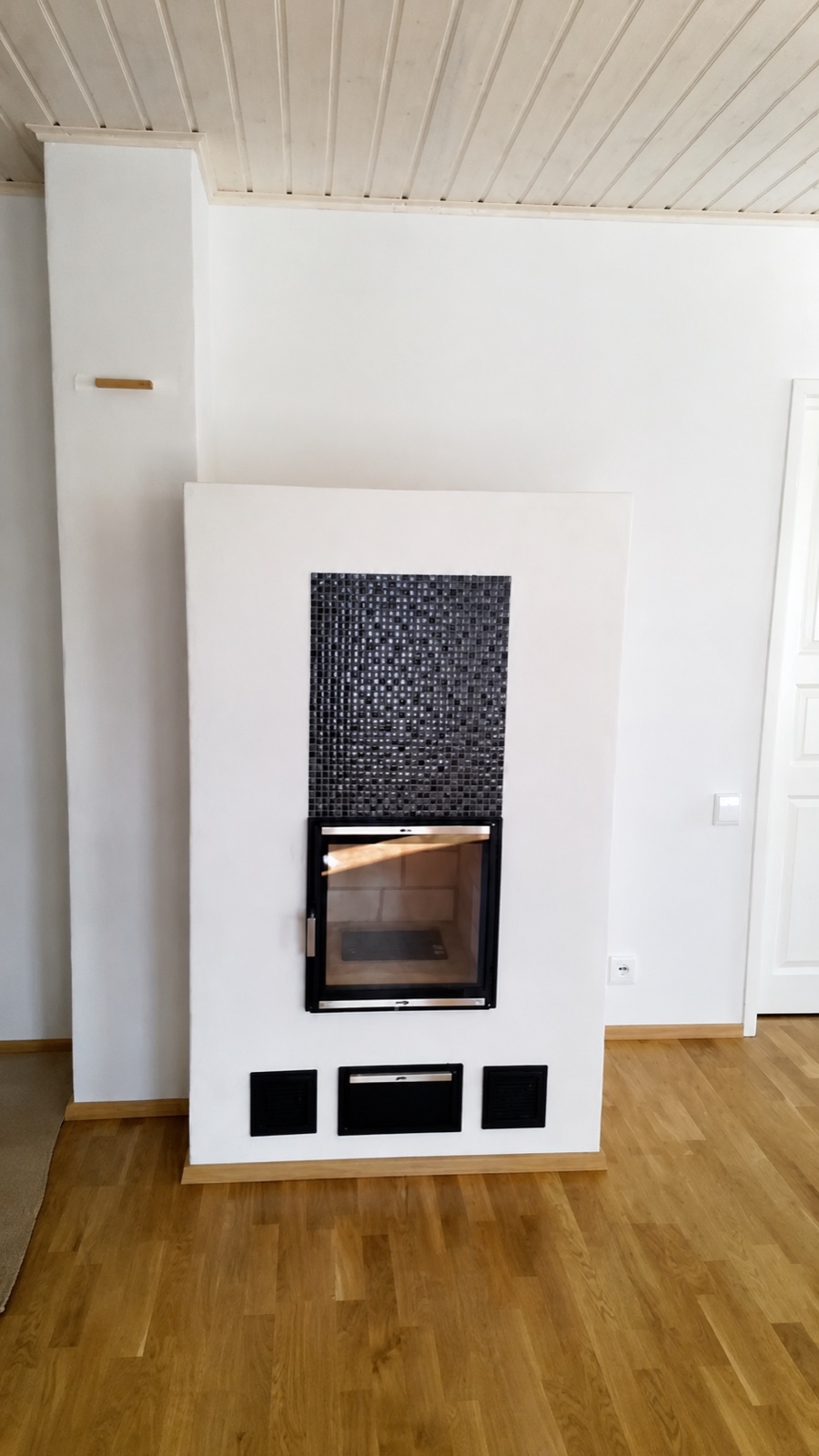Valkoinen takka mosaiikkipintaisella yläosalla